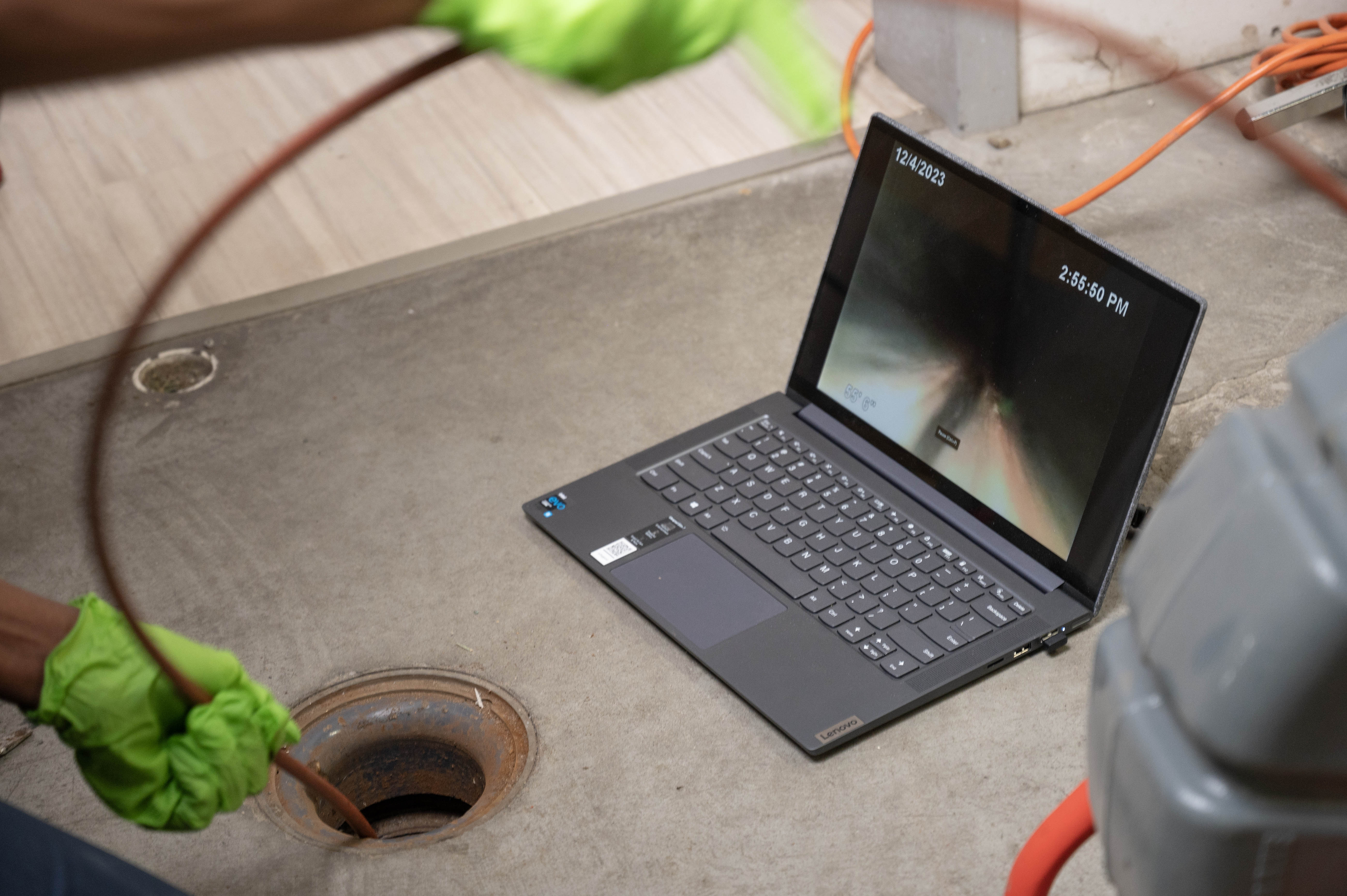 contractor doing an inspection of a drain using a snake camera