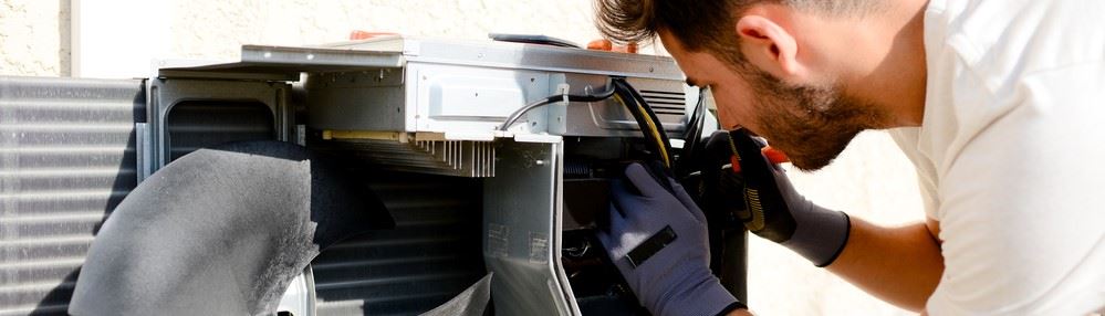 Cregger HVAC expert installing a modern, energy-efficient central air conditioning unit outdoors.