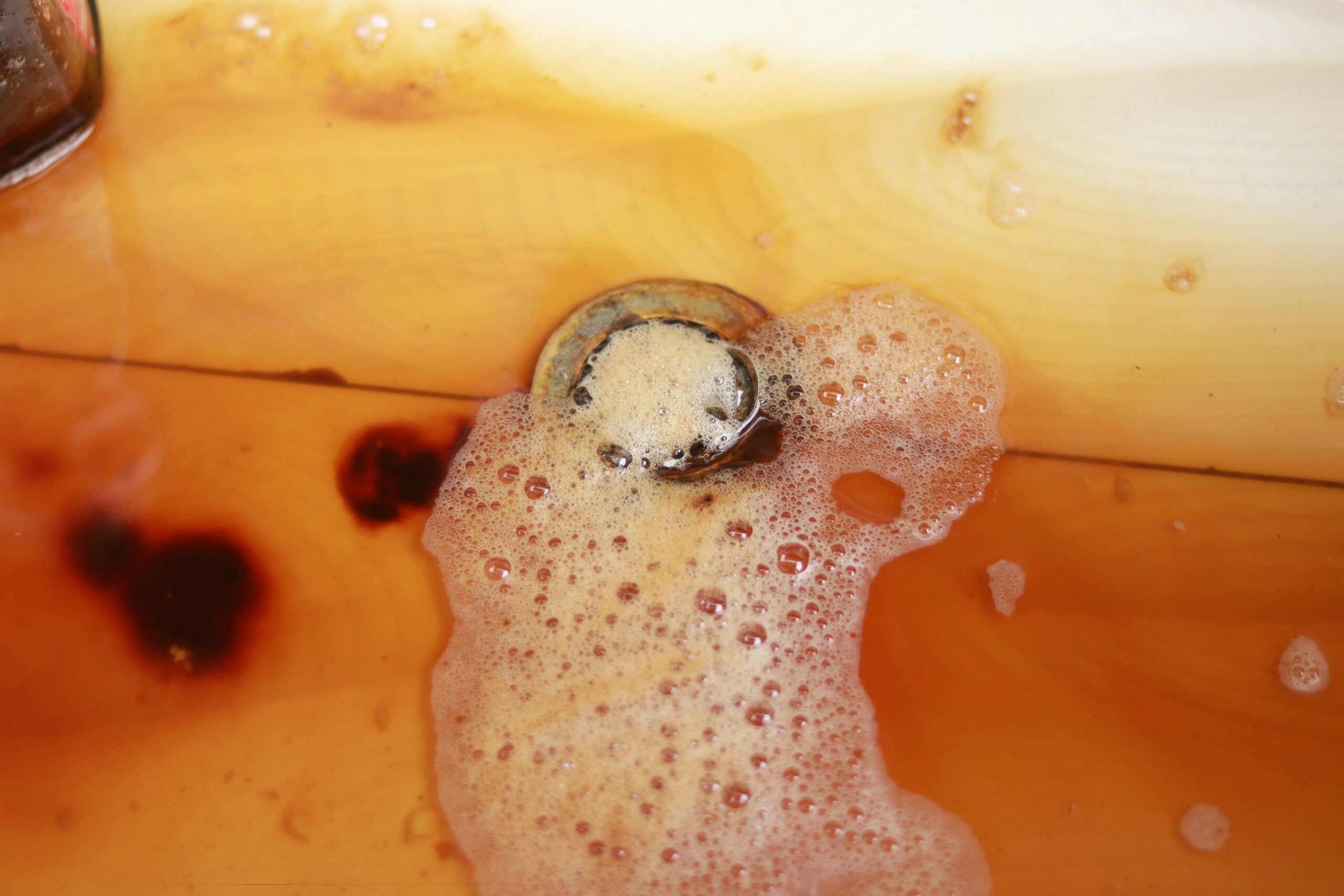 Slow-draining sink with discolored standing water, illustrating a clogged drain that may require DIY cleaning or professional plumbing service in Metro Detroit.