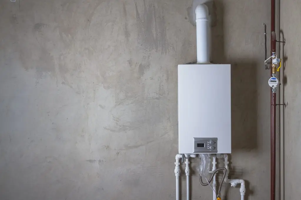 A licensed Cregger plumber installing a modern, energy-efficient tankless water heater in a Taylor basement.